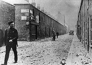 A policeman walks past the debris of a Belfast riot.